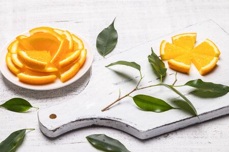 Flower of orange slices on a wooden board.