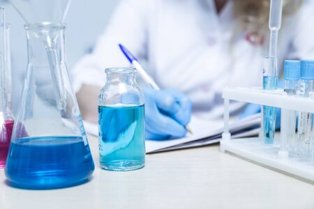 Scientist or doctor in lab coat with test tube with reagent. Laboratory glassware containing chemical liquid.の写真素材