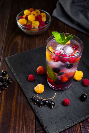 Berry lemonade in a transparent glass on a dark background.の写真素材