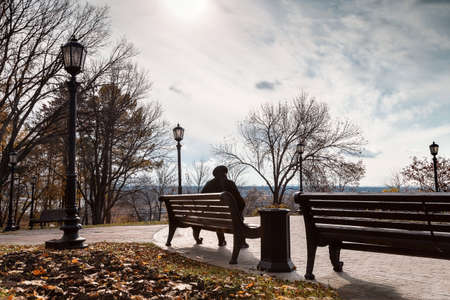 Lonely woman in a park on a bench.の写真素材