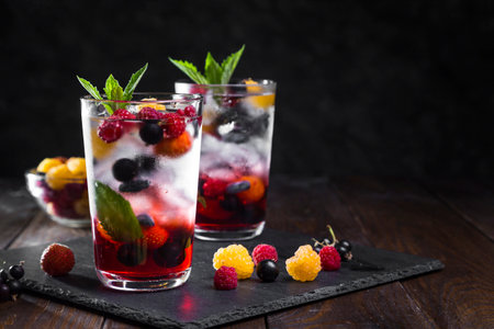 Berry lemonade in a transparent glass on a dark background.の写真素材