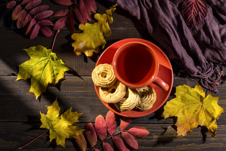 Autumn tea with cookies and autumn leaves on a wooden table.の写真素材