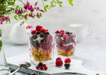 Dessert with a cupcake, raspberries, currants, cherries and ice cream in a glass.の写真素材