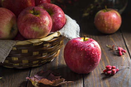 Fresh red apples with drops on a wooden background.の写真素材