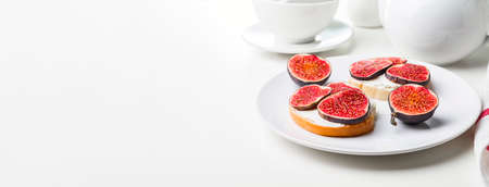 White bread with figs and curd cheese on a white plate.の写真素材