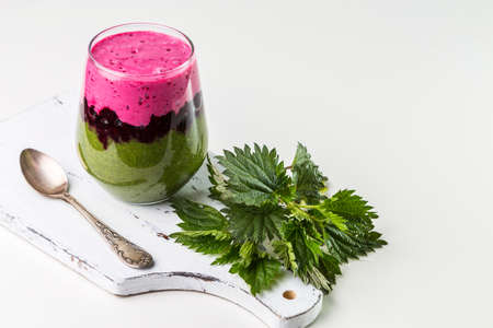 Delicious dessert with black currant interlayer, nettle and currant smoothie. Dessert is served in a glass with a spoon.の写真素材