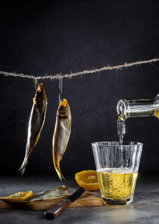 Beer and smoked fish on a dark background.の写真素材
