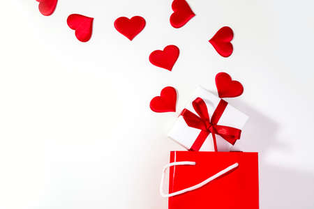 Valentine's day background with red hearts and a gift in a red bag. Flat lay copy space.の写真素材