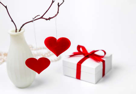A vase of hearts hanging from a branch and a Valentine's Day gift. Copy space.の写真素材