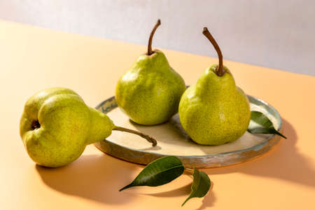 Fresh pears on a plate on a bright background. copyspace.の写真素材