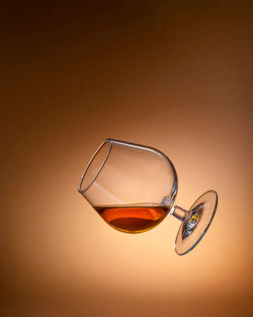 Glass with cognac on a bright background. Levitation. copyspace.の写真素材