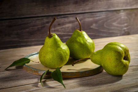 Fresh pears on a plate on a wood background. copyspace.の写真素材