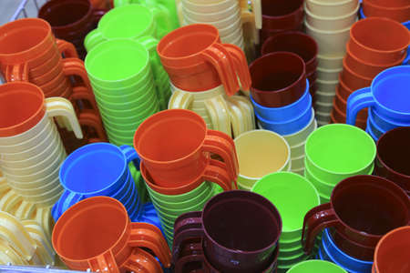 Basket with multi-colored plastic cups. Sale in the store.