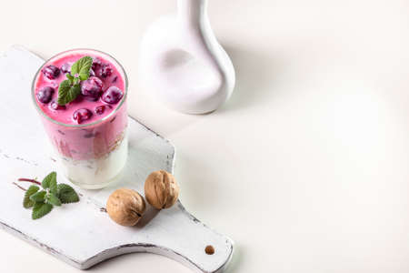 Yogurt, granola with nuts and cherries in a transparent glass. Light and healthy breakfast. copyspace.の写真素材