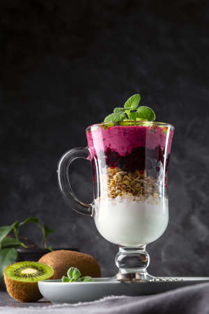 Yogurt smoothie with granola, black currant and kiwi pieces. Delicious and healthy breakfast. copyspace.の写真素材