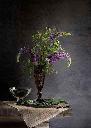 Bouquet of spring lilac lupins and honeysuckle on a wooden table early in the morning. copyspace.の写真素材
