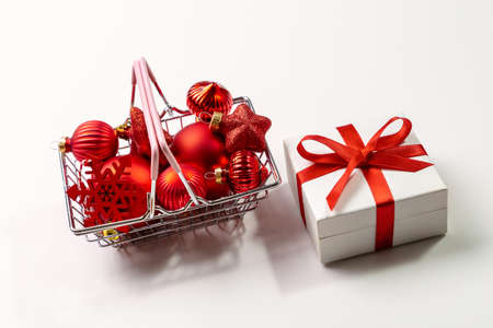 Red Christmas decorations in a shopping cart on a white background. copyspace.の写真素材