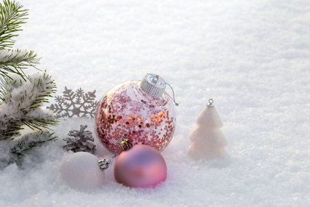 Pink and white Christmas decorations on the snow. copyspace.の写真素材
