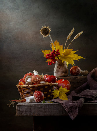 Rustic still life with fly agaric and autumn leaves on a dark background.の写真素材