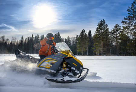 Athlete on a snowmobile moving in the winter forest in the mountains of the Southern Urals.
