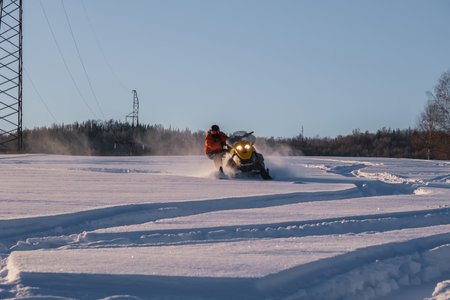 Athlete on a snowmobile moving in the winter forest in the mountains of the Southern Urals.