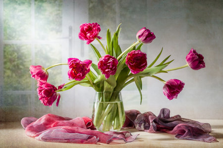 A bouquet of pink tulips in a vase against a window.の写真素材