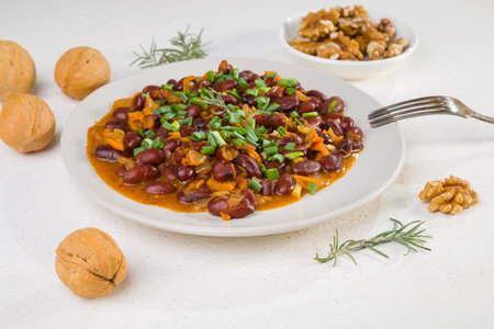 Red beans in tomato sauce with green onions and walnuts. Lenten vegetarian food.の写真素材