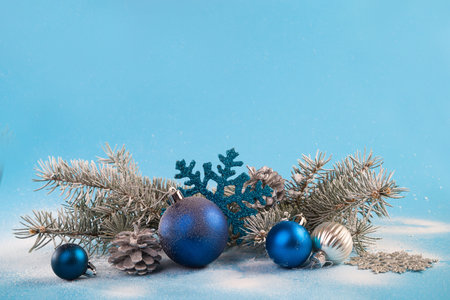 Christmas card with fir branches and Christmas decorations on a light blue background.の写真素材