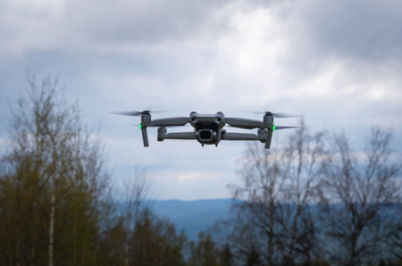 An unmanned aerial vehicle flies in the air low above the ground.