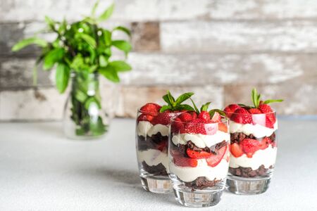 Beautiful dessert with fresh berries. Trifle with chocolate and strawberries on a light background copy space.の写真素材