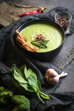 Broccoli cream soup with spinach and croutons on a dark backgroundの写真素材