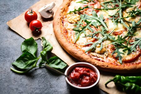 Traditional Italian pizza with eggplants, mozzarella, basil and tomatoes on a dark background copy space.の写真素材