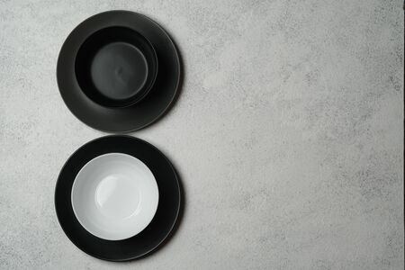 White  and black plates isolated on a light background. Table setting. Top view copy space.の写真素材