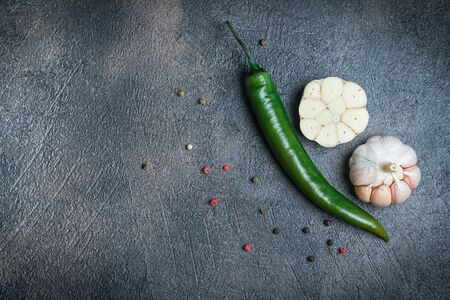 Fresh vegetables on a black background. Garlic and  chili peppers. Top view. Copy space.の写真素材