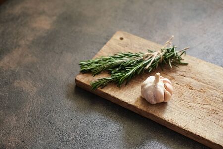 Bunch of fresh rosemary and garlic on a black background.Top view with copy space.の写真素材