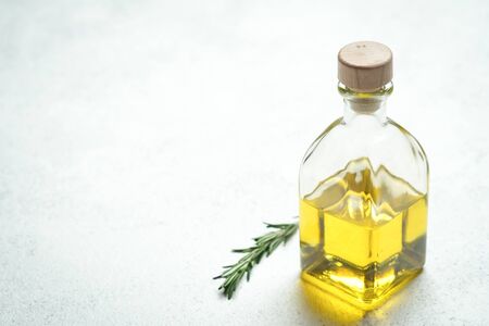 Bunch of fresh rosemary and garlic and bottle with olive oil on a light background.Top view with copy space.の写真素材