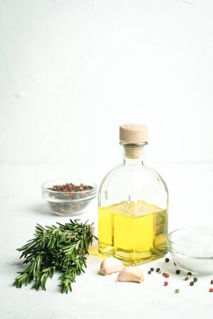 Bunch of fresh rosemary and garlic and bottle with olive oil on a light background.Top view with copy space.の写真素材