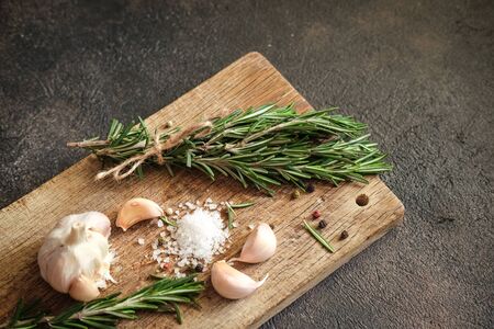 Bunch of fresh rosemary and garlic on a black background.Top view with copy space.の写真素材