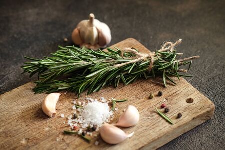 Bunch of fresh rosemary and garlic on a black background.Top view with copy space.の写真素材