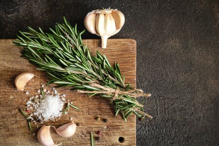 Bunch of fresh rosemary and garlic on a black background.Top view with copy space.の写真素材