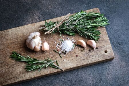Bunch of fresh rosemary and garlic on a black background.Top view with copy space.の写真素材