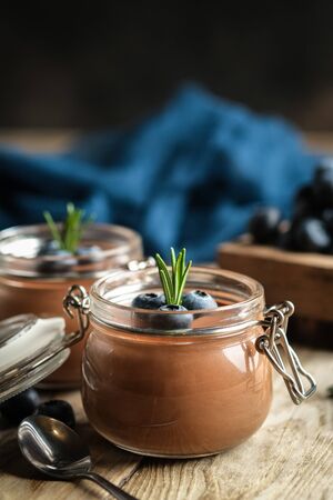 Chocolate mousse in glass jar with berries on a rustic background copy space. Homemade dessert.の写真素材