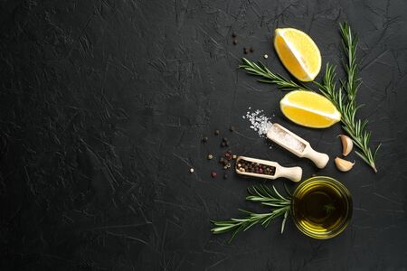 Selection of spices, herbs and lemon. Ingredients for cooking. Food background on dark stone table. Top view copy space.
の写真素材