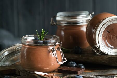 Chocolate mousse in glass jar with berries on a rustic background copy space. Homemade dessert.の写真素材