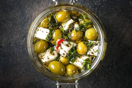 Feta with olives marinated in olive oil with spices. Meze is a dish of Mediterranean cuisine top view copy space.の写真素材