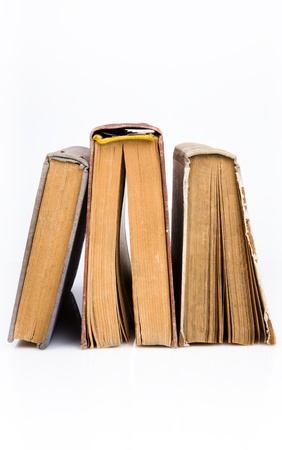 Old books piled together over white backgroundの写真素材