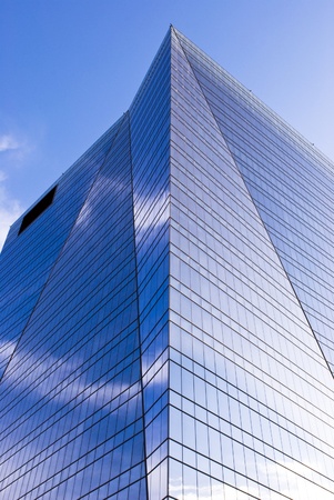 Highrise glass building with sky and clouds reflectionの写真素材