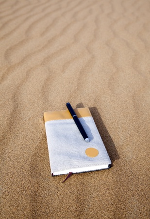 Notebook and pen isolated on desertの写真素材