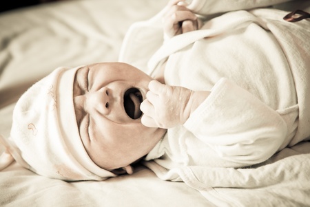 Newborn baby crying on the bed, selective focusの写真素材