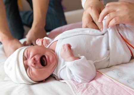 Newborn baby crying on the bed, selective focus